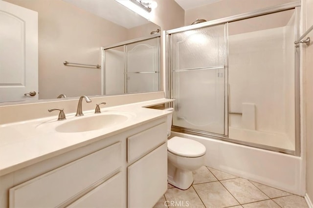 full bathroom featuring tile patterned flooring, combined bath / shower with glass door, vanity, and toilet