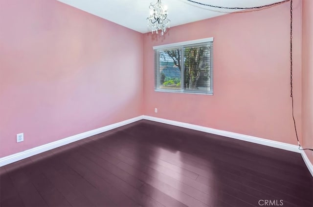 empty room featuring hardwood / wood-style floors and an inviting chandelier