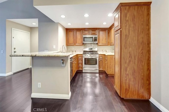23556 Cambridge Rd Unit 327, Yorba Linda, CA 92887 - kitchen featuring light stone countertops, brown cabinets, a peninsula, dark wood-style floors, and stainless steel appliances