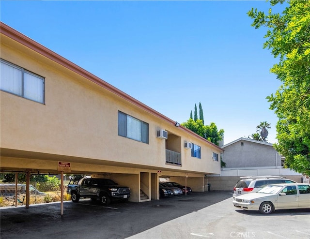 view of parking with an AC wall unit