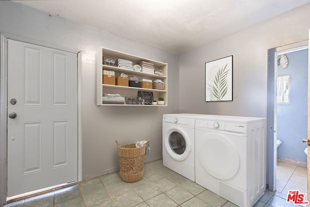 washroom featuring light tile patterned flooring and washing machine and clothes dryer