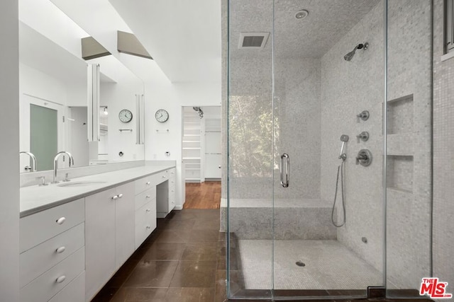 bathroom featuring tile patterned flooring, vanity, and a shower with shower door