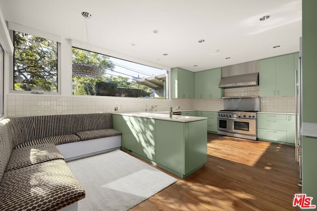 kitchen featuring ventilation hood, double oven range, and green cabinets