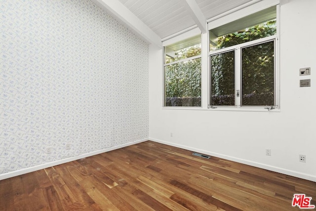 spare room with lofted ceiling with beams and hardwood / wood-style flooring