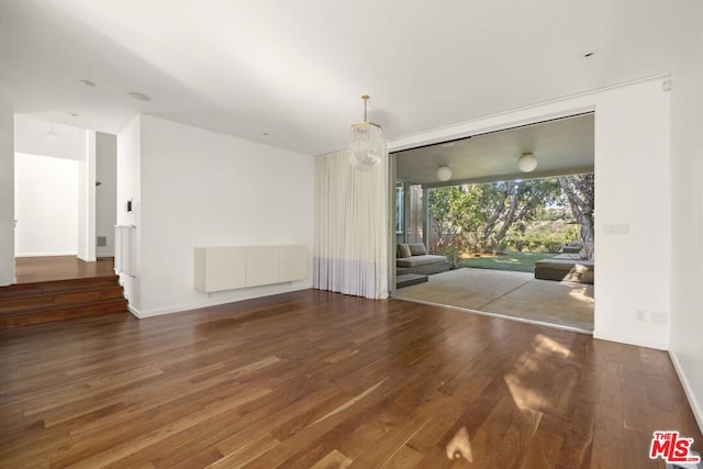 unfurnished room featuring a chandelier and hardwood / wood-style flooring