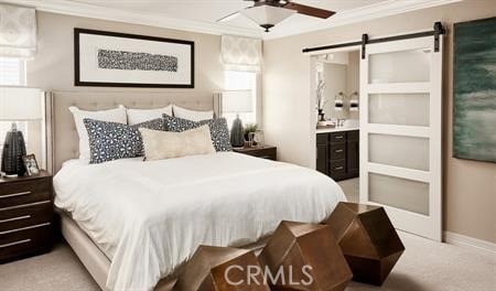 carpeted bedroom with a barn door, ornamental molding, ensuite bathroom, and ceiling fan