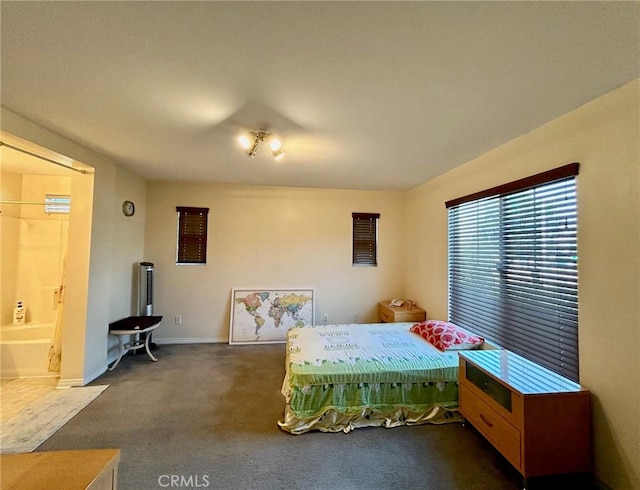 bedroom featuring dark colored carpet and ensuite bathroom