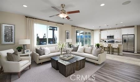 living room featuring plenty of natural light and ceiling fan