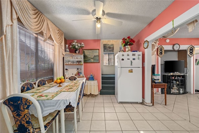 kitchen featuring ceiling fan, a textured ceiling, light tile patterned floors, and white refrigerator