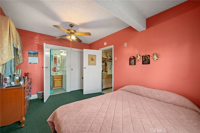 carpeted bedroom with ceiling fan, a textured ceiling, beam ceiling, and ensuite bath