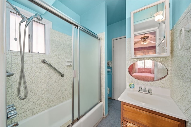 bathroom featuring vanity, combined bath / shower with glass door, and ceiling fan