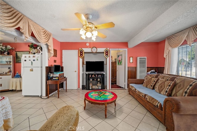 tiled living room with ceiling fan and a textured ceiling