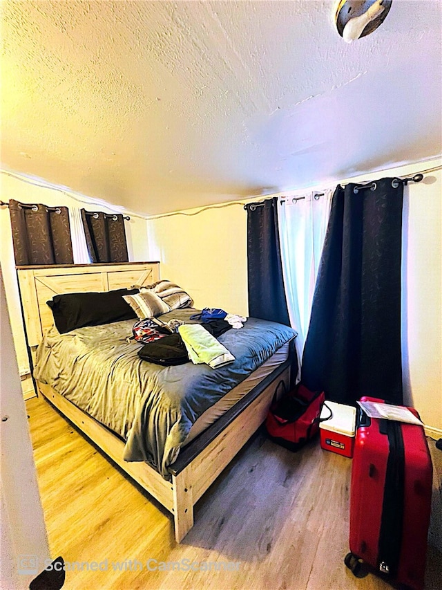 bedroom featuring hardwood / wood-style flooring and a textured ceiling