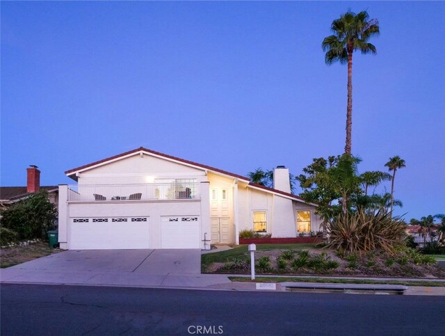 view of front of home with a garage and a balcony