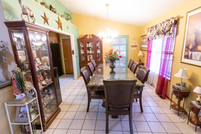 tiled dining room with lofted ceiling and a chandelier