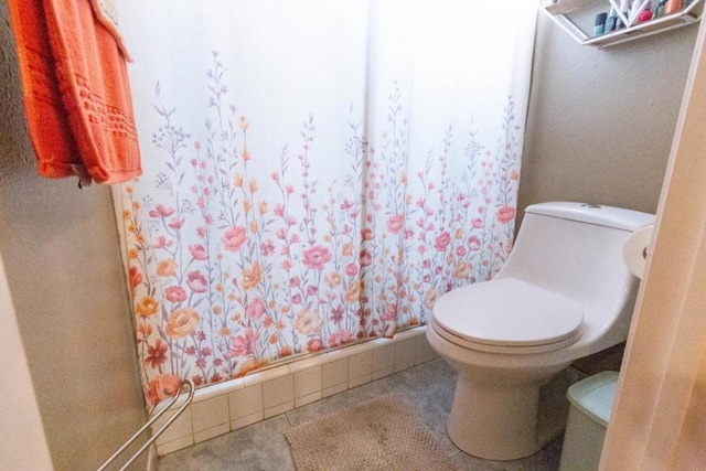 bathroom featuring toilet, walk in shower, and tile patterned flooring