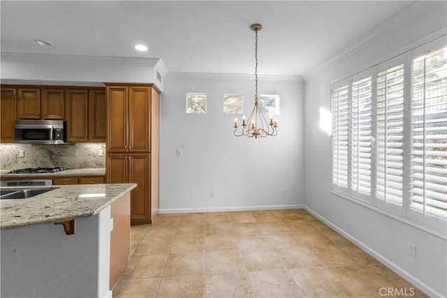 kitchen with baseboards, a healthy amount of sunlight, stainless steel microwave, and brown cabinets