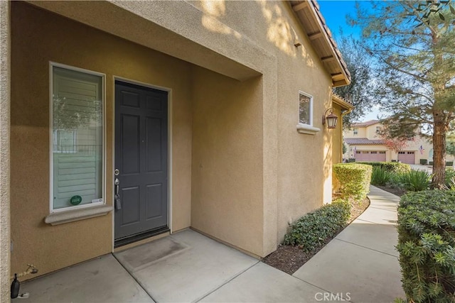 view of exterior entry with stucco siding