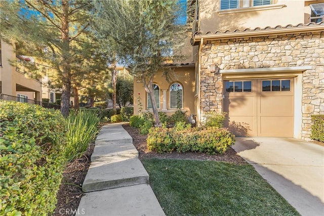 entrance to property with driveway and stucco siding