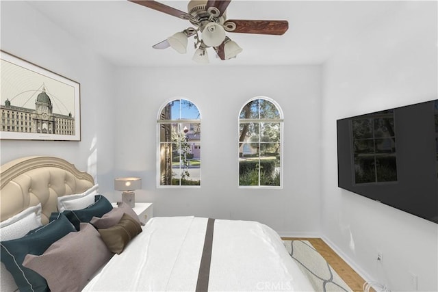 bedroom with a ceiling fan and baseboards