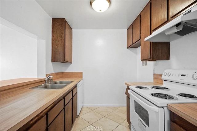 kitchen featuring light tile patterned flooring, sink, and white appliances