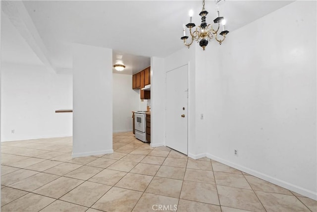 tiled empty room featuring an inviting chandelier