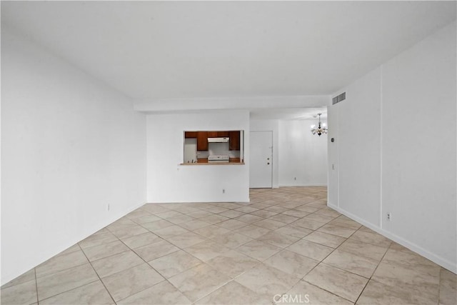 unfurnished room with light tile patterned floors and a notable chandelier