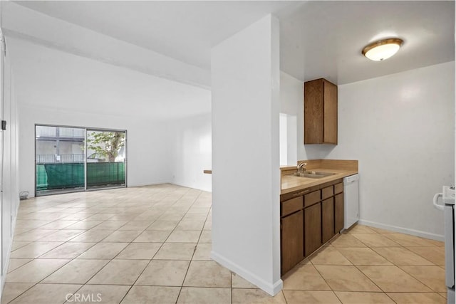 kitchen with sink, light tile patterned flooring, and white dishwasher