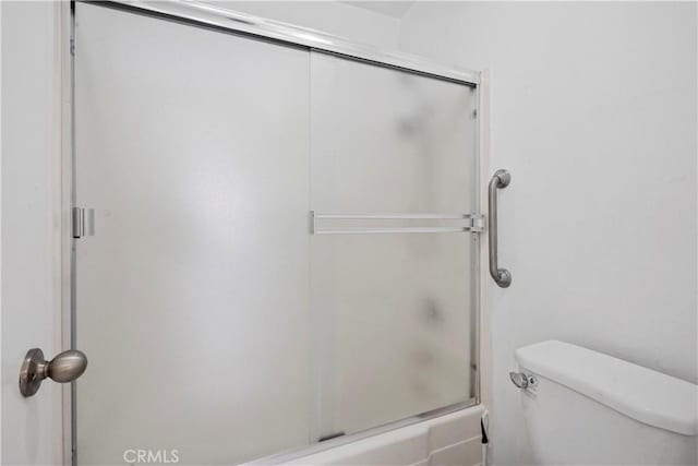 bathroom with toilet and a shower with shower door