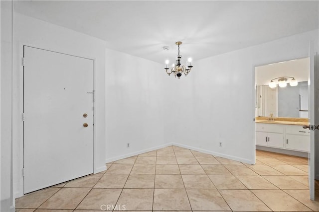 interior space with light tile patterned floors, a chandelier, and sink