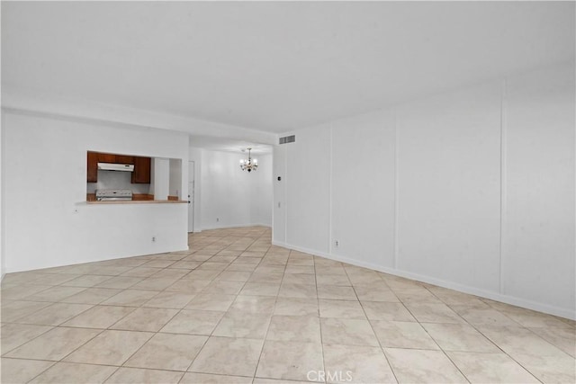 tiled empty room featuring an inviting chandelier