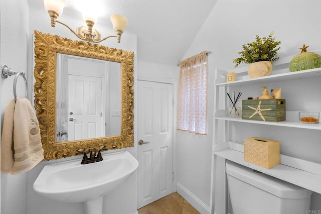 bathroom featuring tile patterned flooring, sink, lofted ceiling, and toilet