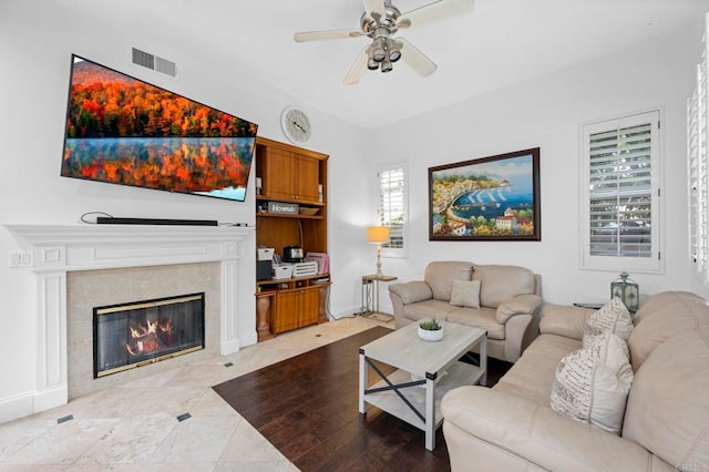 living room with ceiling fan and a premium fireplace