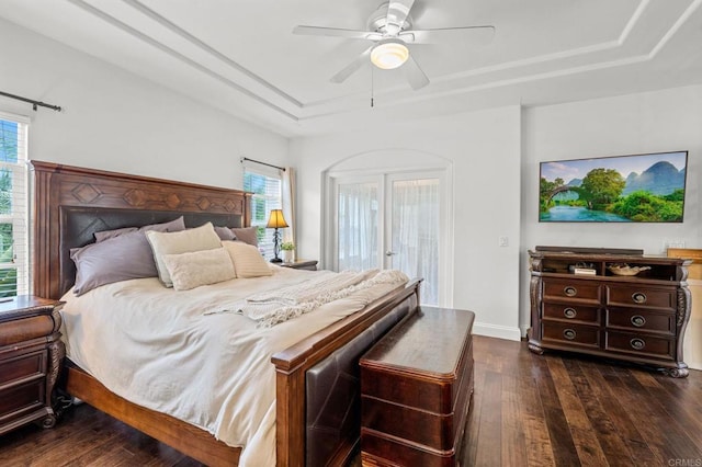 bedroom featuring ceiling fan, a tray ceiling, dark hardwood / wood-style flooring, and access to outside