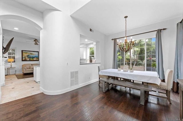 dining area featuring ceiling fan with notable chandelier, a healthy amount of sunlight, and hardwood / wood-style floors