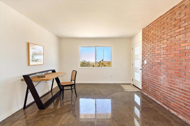 office space with concrete floors and brick wall