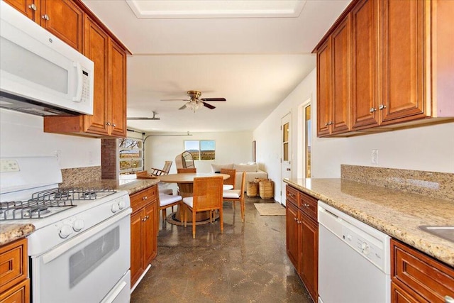 kitchen with ceiling fan, light stone countertops, and white appliances