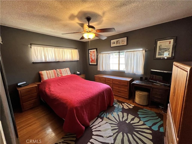 bedroom with ceiling fan, a textured ceiling, and light hardwood / wood-style floors