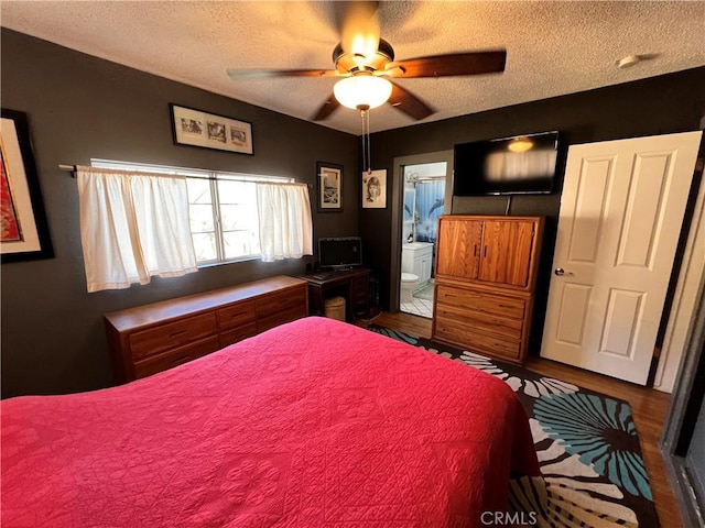 bedroom with ensuite bath, ceiling fan, and a textured ceiling