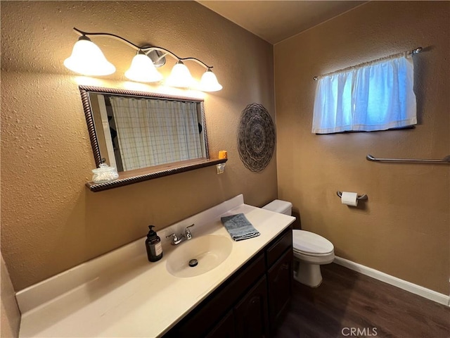 bathroom featuring hardwood / wood-style flooring, toilet, and vanity