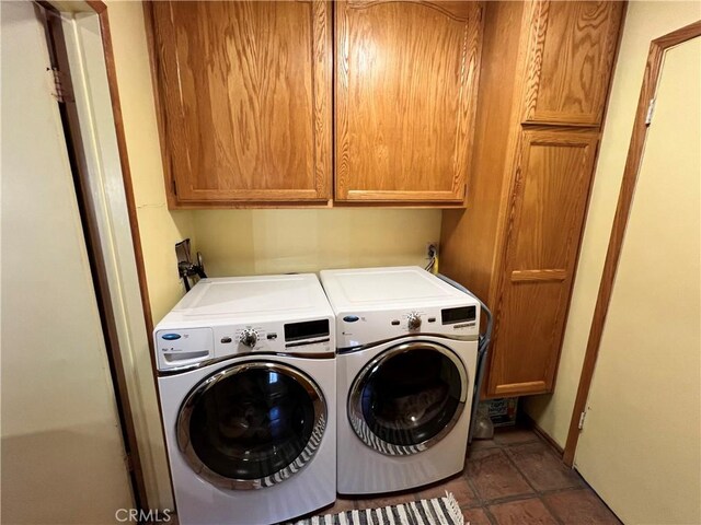 laundry area featuring washer and clothes dryer and cabinets