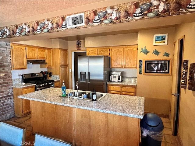 kitchen with a textured ceiling, stainless steel appliances, and sink