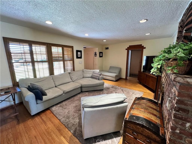 living room featuring a textured ceiling and light hardwood / wood-style floors