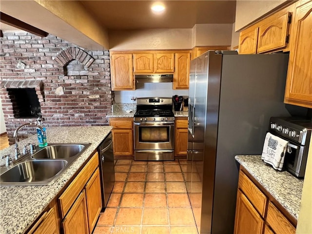 kitchen with light stone counters, sink, appliances with stainless steel finishes, and light tile patterned floors