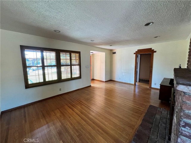 unfurnished living room with a textured ceiling and hardwood / wood-style flooring