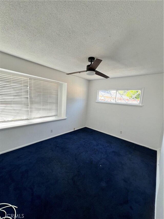 carpeted empty room with a textured ceiling and ceiling fan