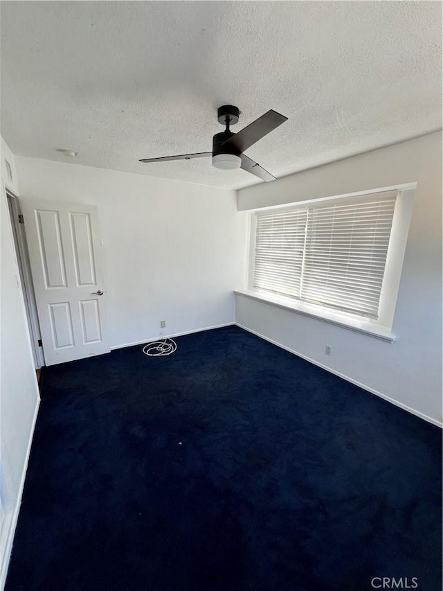 carpeted spare room with a textured ceiling and ceiling fan