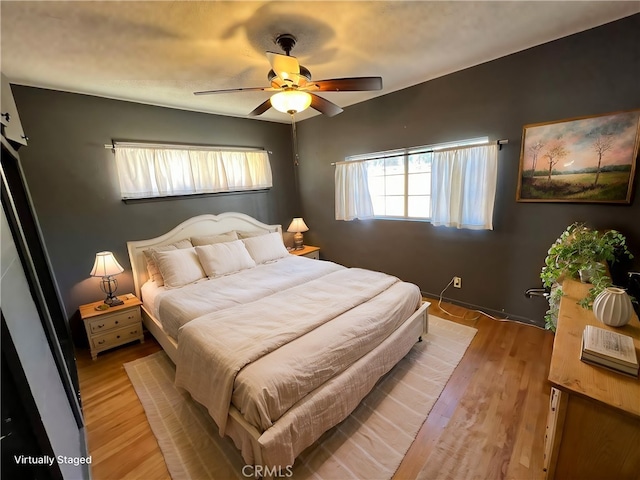 bedroom with ceiling fan and light hardwood / wood-style flooring