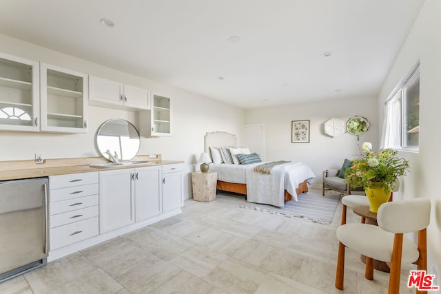 bedroom featuring stainless steel refrigerator and sink