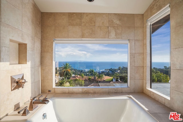 bathroom with a water view and tile walls